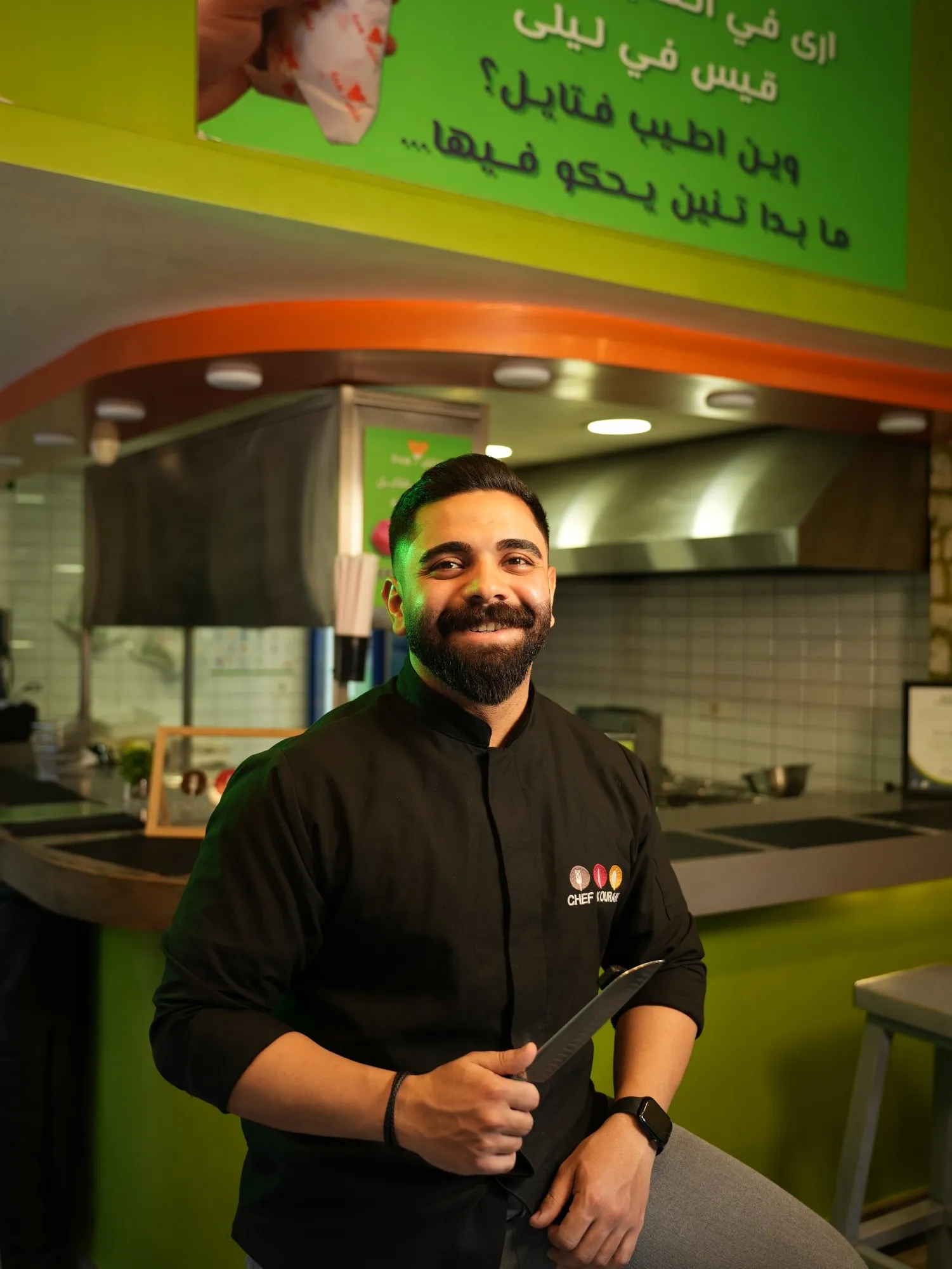 Chef in a black jacket holding a knife in the Fateyil Warde kitchen
